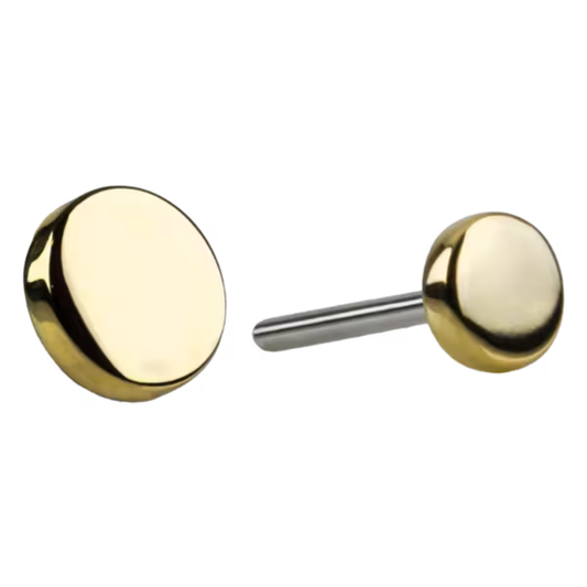 Close-up of a polished round gold disc end with titanium post, luxury body piercing jewellery for a refined and minimalist look