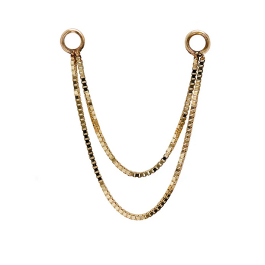 Close-up of a Quetzalli Double Box Chain made from solid gold, featuring two sleek rows of box-cut links joined by circular ends, designed for connecting multiple piercings in a luxury style.