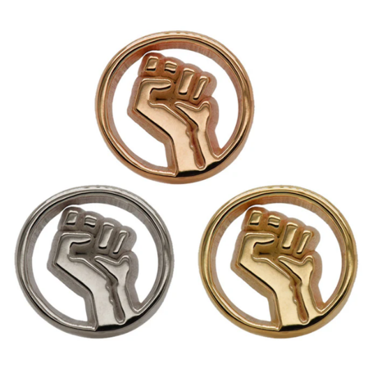 Three Quetzalli Resist threadless ends in yellow, white, and rose gold, featuring a raised fist within a circular frame, photographed against a white background to highlight their polished, sculptural detail.