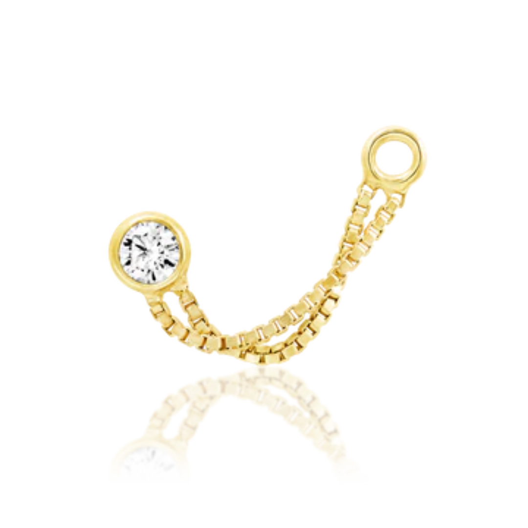 Gold chain charm featuring a bezel-set clear gemstone and double draped chains, designed for attachment to piercings with jump rings