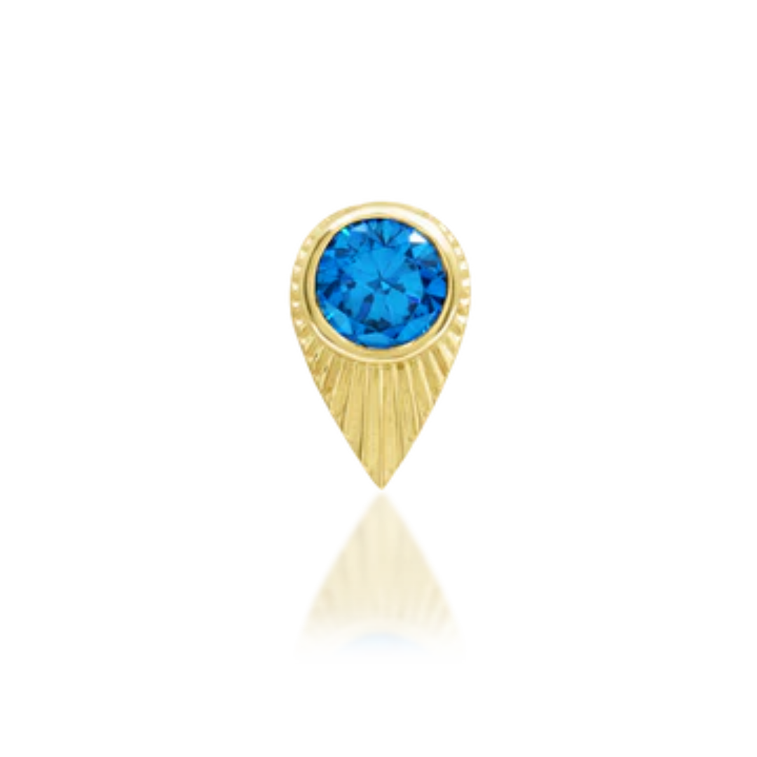 14k gold piercing stud with a brilliant round blue CZ set in a pointed sunburst teardrop frame.