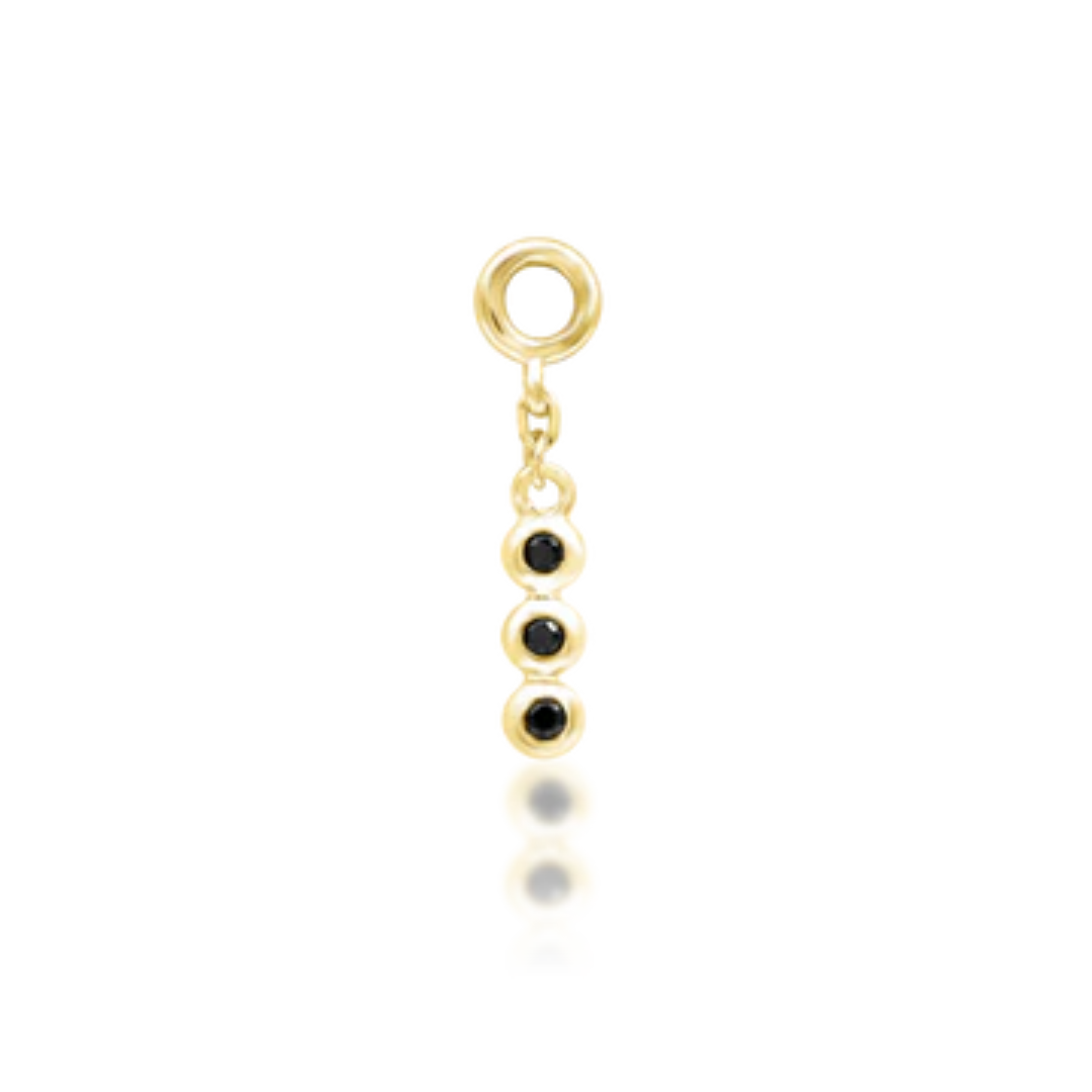 gold piercing charm with three bezel-set black stones in a vertical drop design