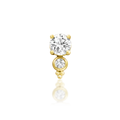 Very shiny 14k gold body jewellery featuring a brilliant round-cut cubic zirconia paired with a bezel-set CZ accent and delicate gold beading. A radiant and elegant piece for helix, flat, or lobe piercings