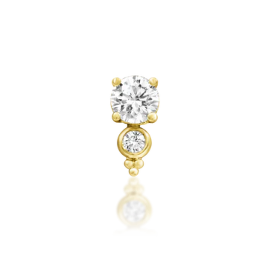 Very shiny 14k gold body jewellery featuring a brilliant round-cut cubic zirconia paired with a bezel-set CZ accent and delicate gold beading. A radiant and elegant piece for helix, flat, or lobe piercings