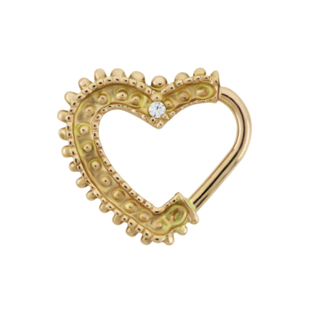 Le Roi 14k gold heart shaped ring with beaded texture and a single clear gemstone accent designed for daith or septum piercings