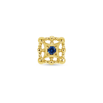 Close-up of a Norvoch gold square piercing end with ornate beaded detailing and a deep blue gemstone set at the centre