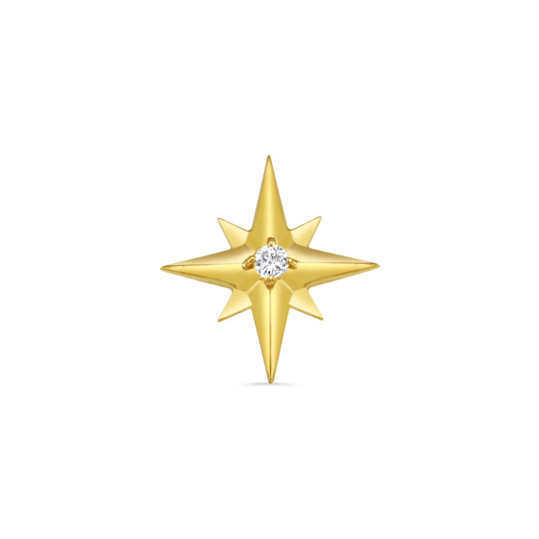Close-up of a Norvoch gold star-shaped piercing end with eight sharp points and a central round cubic zirconia gemstone set in polished yellow gold