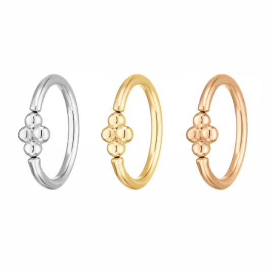 Three Quetzalli Baby Gita rings in 14k yellow, rose, and white gold, each featuring a smooth circular hoop with a small four-bead cluster detail at the front, photographed against a white background.
