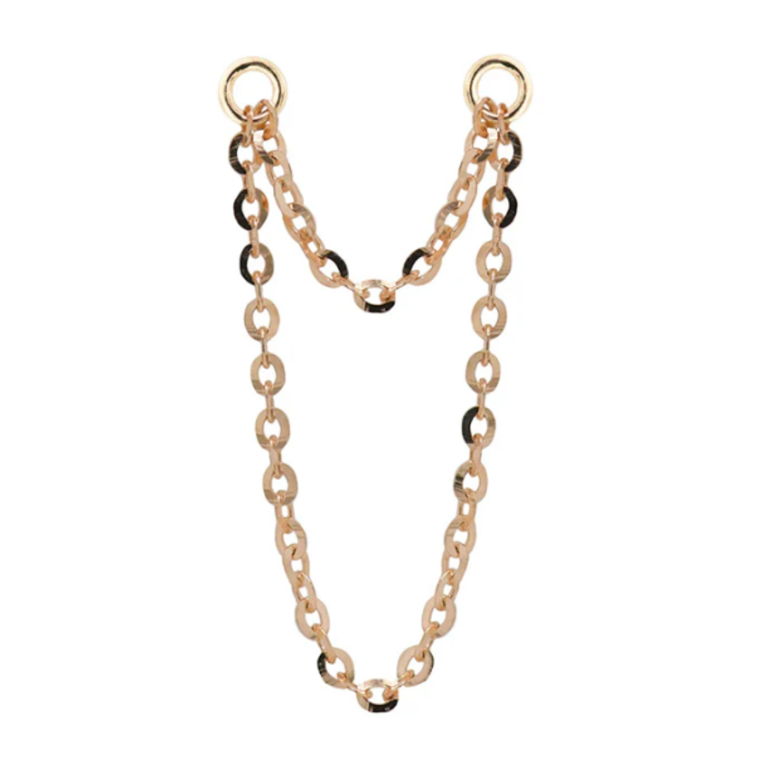 Close-up of a Quetzalli Double Flash Chain made from solid gold, featuring two interlinked rows of high-polish oval links joined by circular ends, designed to connect multiple piercings with a fluid, elegant drape.