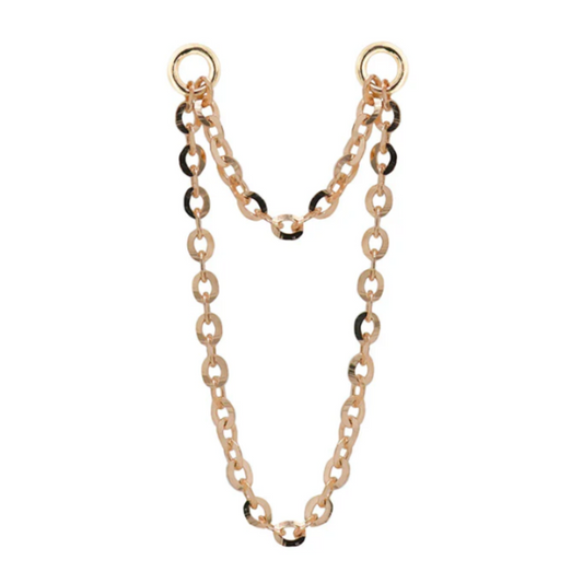 Close-up of a Quetzalli Double Flash Chain made from solid gold, featuring two interlinked rows of high-polish oval links joined by circular ends, designed to connect multiple piercings with a fluid, elegant drape.